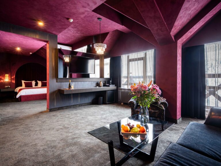 Suite with burgundy walls and sitting area at Premier Luxury Mountain Resort, Bansko