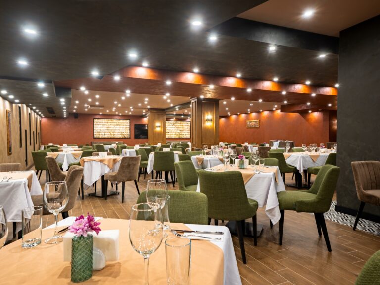 Elysium restaurant dining area with green chairs at Premier Luxury Mountain Resort, Bansko
