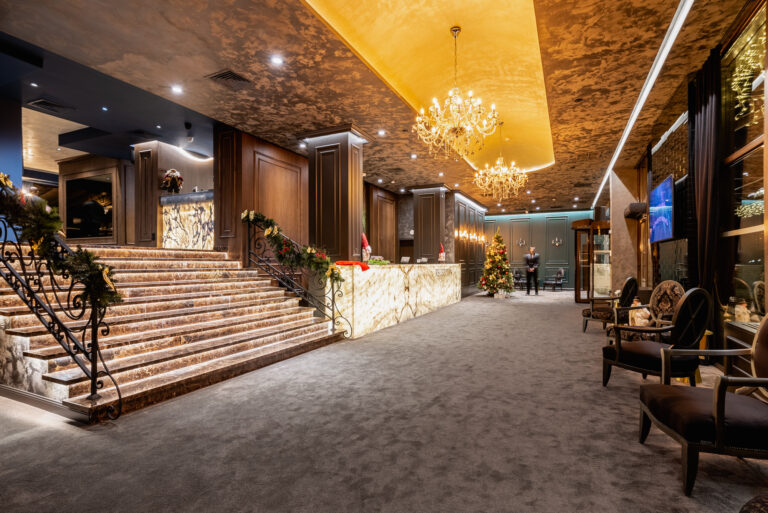 Lobby with backlit onyx reception desk and staircase at Premier Luxury Mountain Resort, Bansko