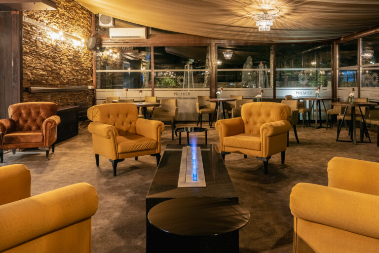 Lobby bar seating with yellow armchairs at Premier Luxury Mountain Resort, Bansko