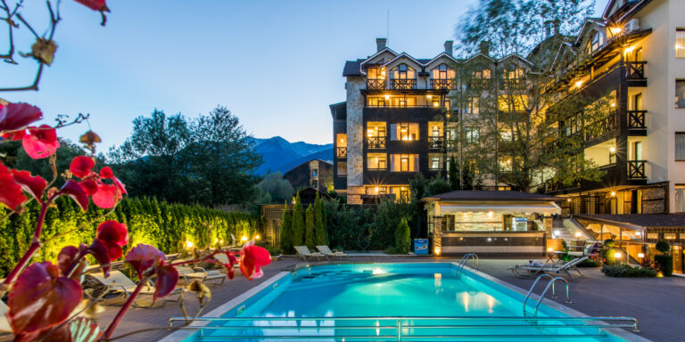 Outdoor pool and hotel building at sunset at Premier Luxury Mountain Resort, Bansko