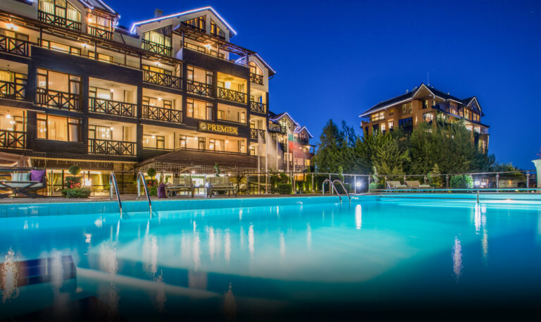 Outdoor pool and hotel facade at dusk at Premier Luxury Mountain Resort, Bansko