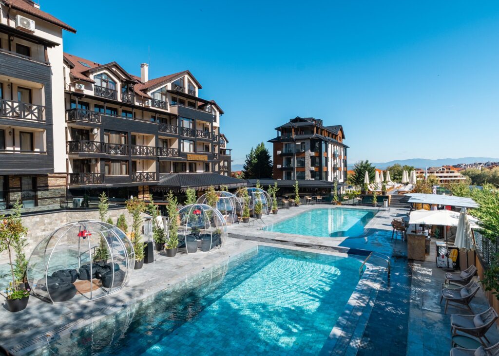Igloos along the pool terrace on a sunny day at Premier Luxury Mountain Resort, Bansko
