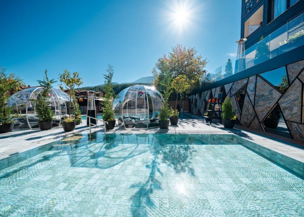 Outdoor pool and igloos in the sunshine at Premier Luxury Mountain Resort, Bansko