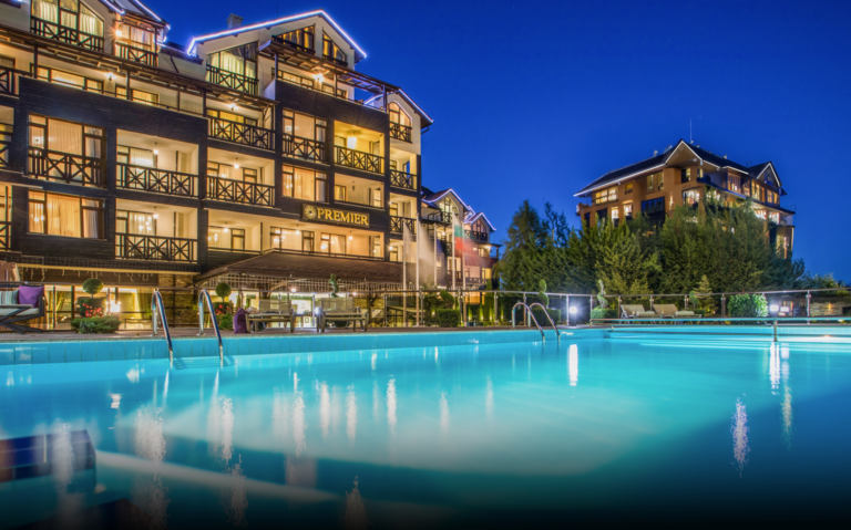 Outdoor pool at night in front of Premier Luxury Mountain Resort, Bansko