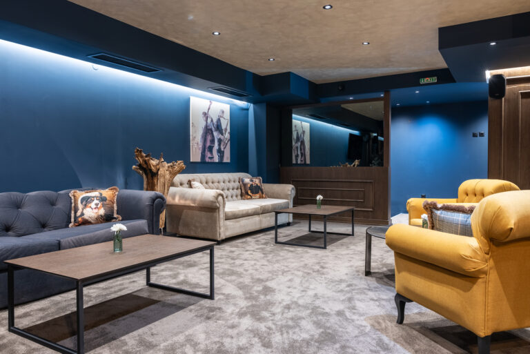 Lounge with navy walls and yellow armchairs at Premier Luxury Mountain Resort, Bansko