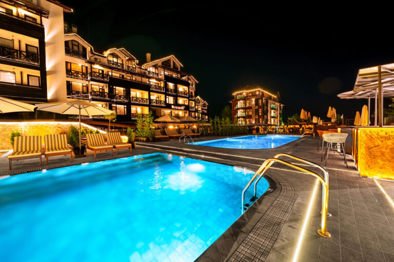 Large outdoor pool lit up at night at Premier Luxury Mountain Resort, Bansko