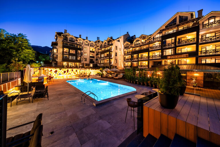 Large outdoor pool lit up at night at Premier Luxury Mountain Resort, Bansko