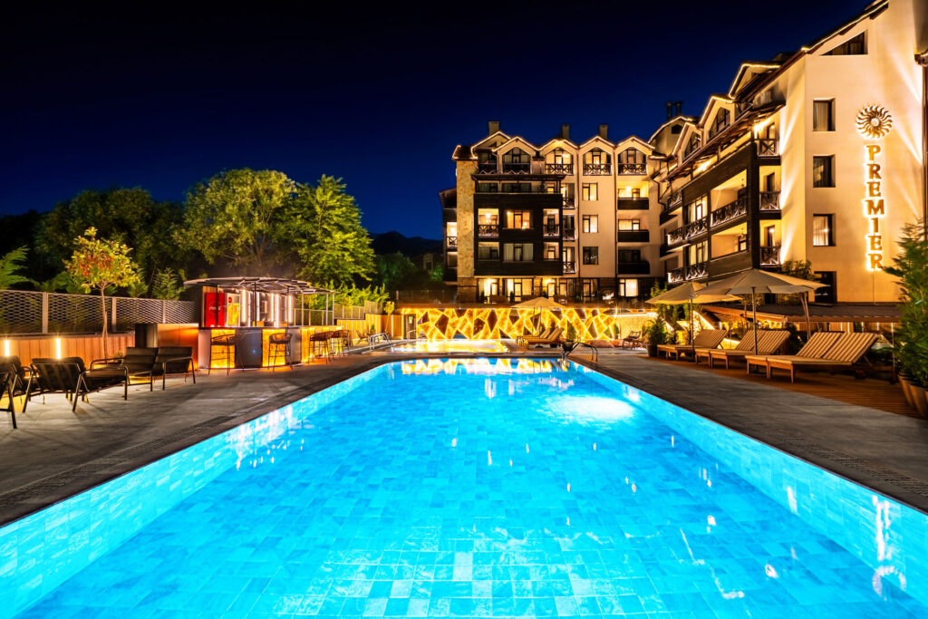 Large outdoor pool lit up at night at Premier Luxury Mountain Resort, Bansko