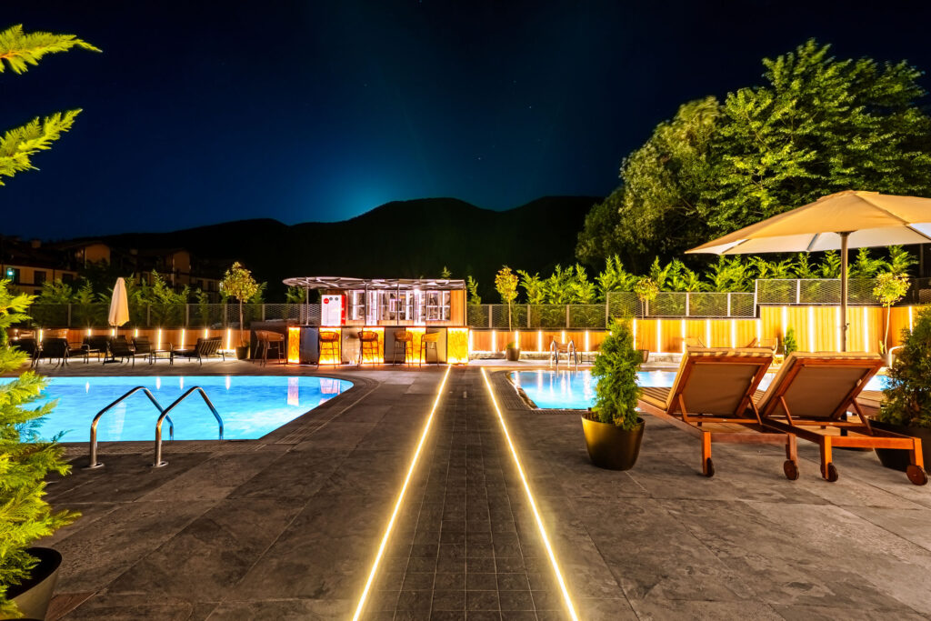 Large outdoor pool lit up at night at Premier Luxury Mountain Resort, Bansko