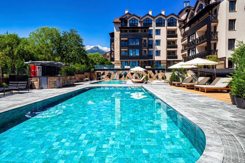 Large heated outdoor pool with Pirin mountain views at Premier Luxury Mountain Resort, Bansko