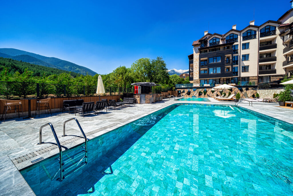 Large heated outdoor pool with Pirin mountain views at Premier Luxury Mountain Resort, Bansko