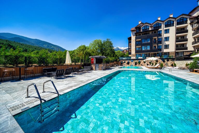 Large heated outdoor pool with Pirin mountain views at Premier Luxury Mountain Resort, Bansko