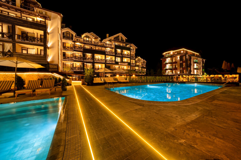 Illuminated outdoor pool and resort buildings at night at Premier Luxury Mountain Resort, Bansko