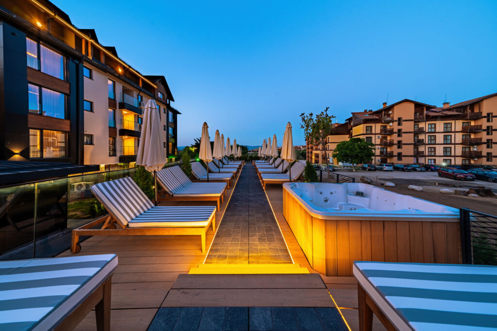 Outdoor jacuzzi on the sun terrace at dusk at Premier Luxury Mountain Resort, Bansko