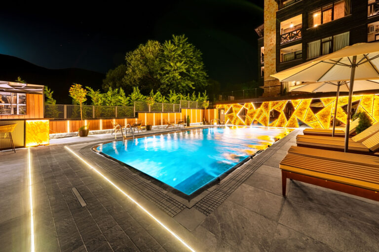 Illuminated outdoor pool at night at Premier Luxury Mountain Resort, Bansko