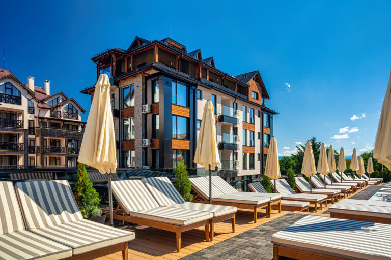 Sun loungers and parasols on the pool terrace at Premier Luxury Mountain Resort, Bansko