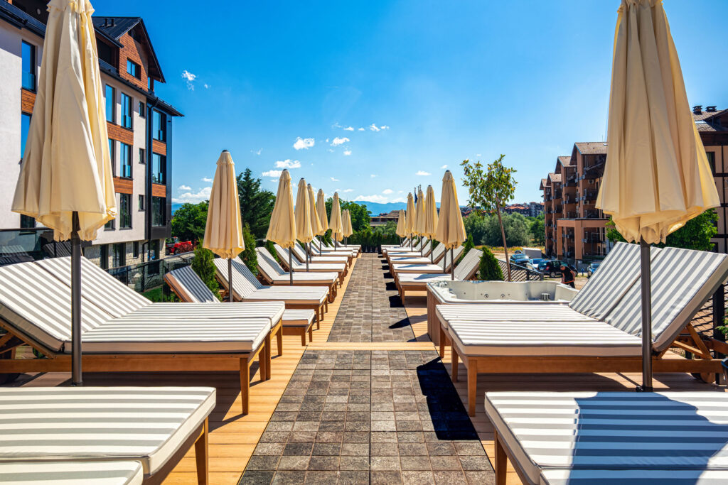 Sun loungers and parasols on the pool terrace at Premier Luxury Mountain Resort, Bansko