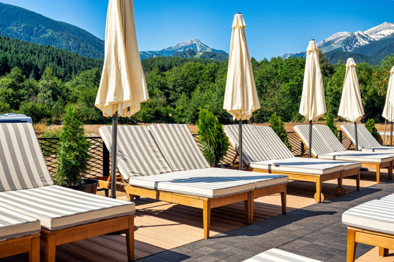 Sun loungers and parasols on the pool terrace at Premier Luxury Mountain Resort, Bansko